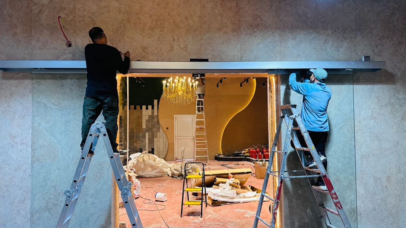 Team installing automatic sliding glass door at luxury Dubai showroom