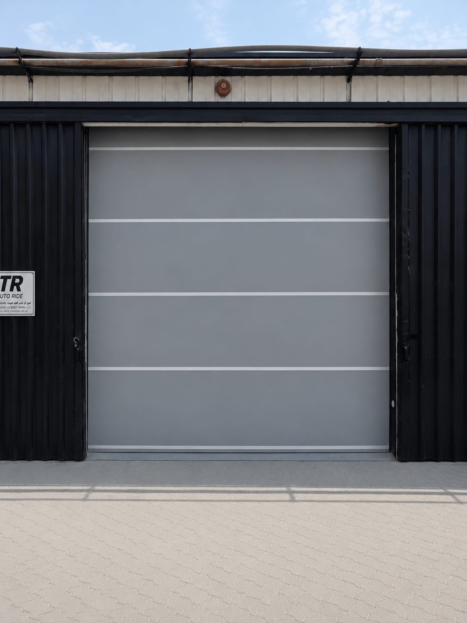 Industrial grey sectional garage door installation at Dubai warehouse