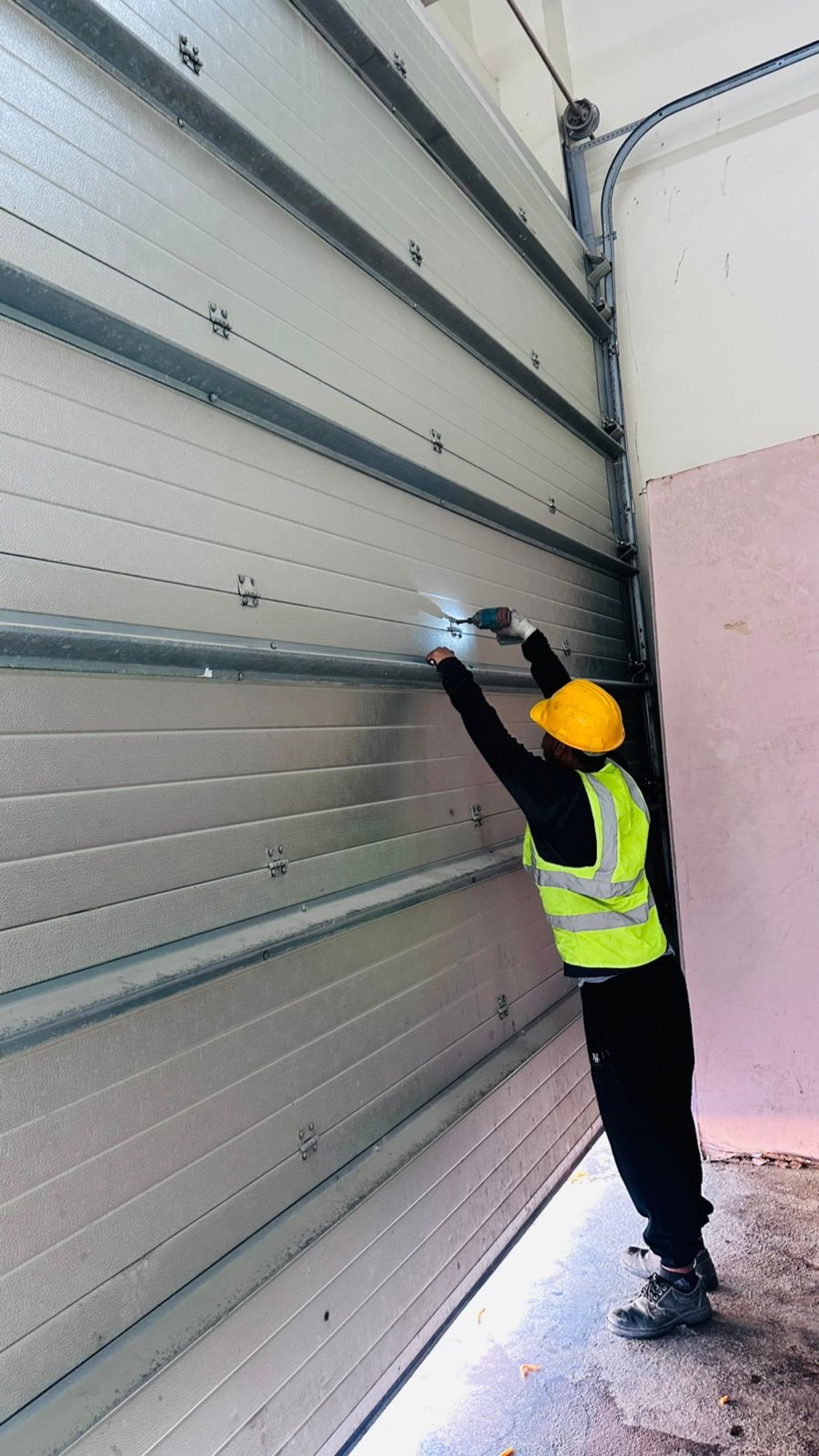 Certified technician installing insulated sectional garage door in Dubai