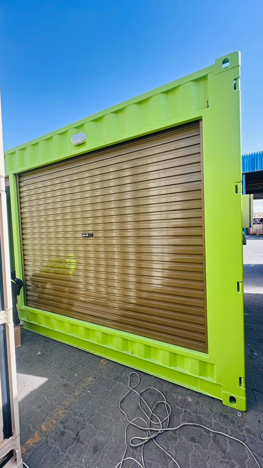 Bronze rolling shutter installed on green container in Dubai